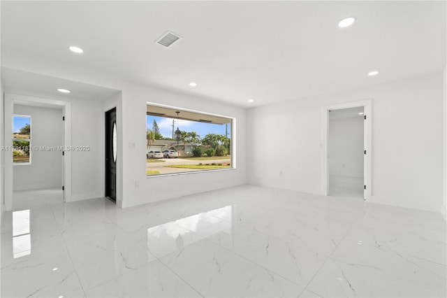 spare room featuring visible vents, baseboards, recessed lighting, and marble finish floor