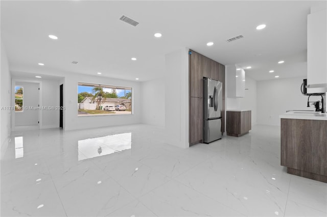 interior space with a sink, visible vents, recessed lighting, and marble finish floor