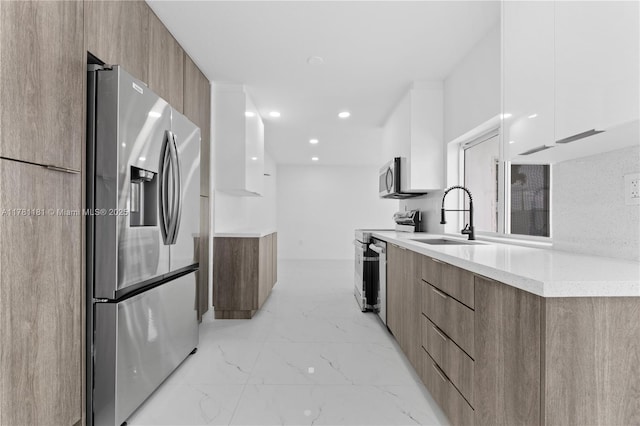 kitchen featuring modern cabinets, a sink, and appliances with stainless steel finishes