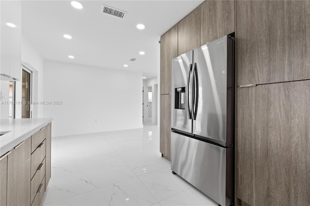 kitchen featuring marble finish floor, stainless steel fridge with ice dispenser, modern cabinets, and visible vents