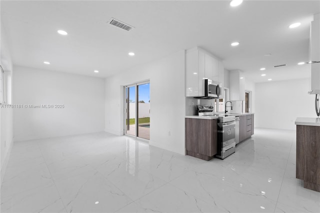 kitchen with visible vents, white cabinets, modern cabinets, light countertops, and stainless steel appliances