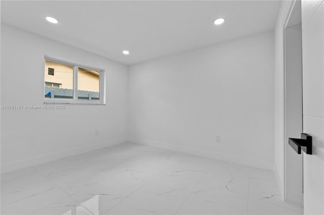 empty room with marble finish floor, baseboards, and recessed lighting