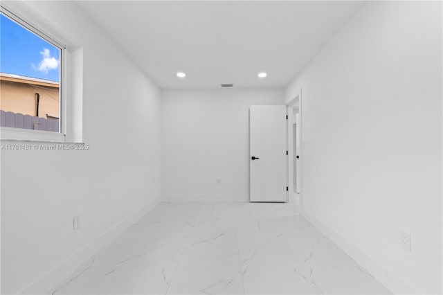 unfurnished room with recessed lighting, marble finish floor, baseboards, and visible vents
