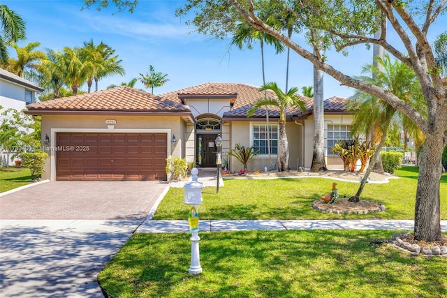 mediterranean / spanish house with stucco siding, driveway, a front yard, a garage, and a tiled roof