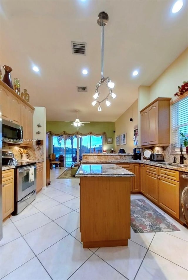 kitchen with tasteful backsplash, visible vents, a sink, appliances with stainless steel finishes, and a peninsula