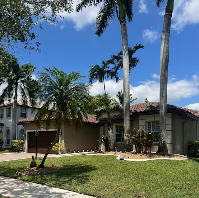 view of front facade with a tiled roof, an attached garage, and stucco siding