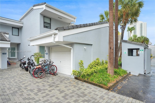311 Poinciana Dr Unit 801, Sunny Isles Beach, FL 33160 - view of property exterior featuring stucco siding, decorative driveway, and a tile roof