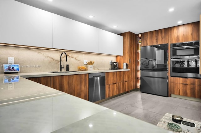 311 Poinciana Dr Unit 801, Sunny Isles Beach, FL 33160 - kitchen with modern cabinets, light countertops, a sink, stainless steel appliances, and brown cabinets