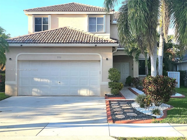 mediterranean / spanish-style home with a garage, driveway, a tiled roof, and stucco siding