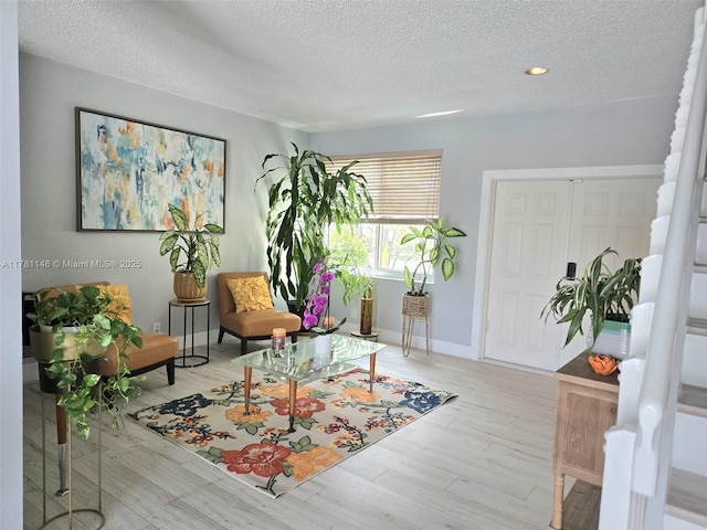 sitting room featuring recessed lighting, a textured ceiling, baseboards, and wood finished floors