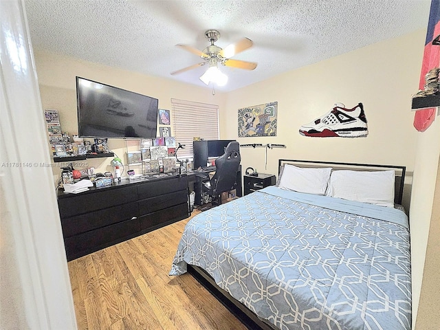 bedroom with a textured ceiling, a ceiling fan, and wood finished floors