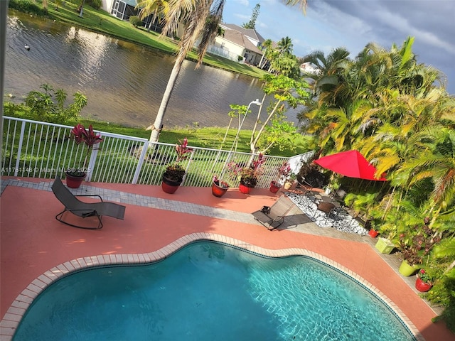 view of swimming pool featuring a patio, a fenced in pool, fence, and a water view