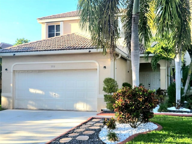 mediterranean / spanish home with concrete driveway, an attached garage, a tile roof, and stucco siding