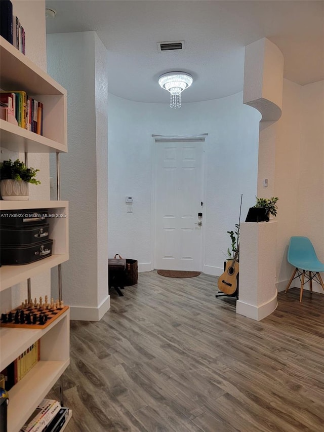 foyer entrance with baseboards and wood finished floors