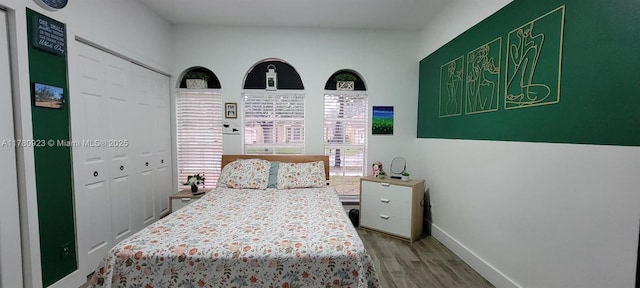 bedroom with baseboards and wood finished floors