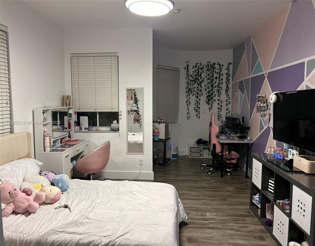 bedroom featuring baseboards and wood finished floors