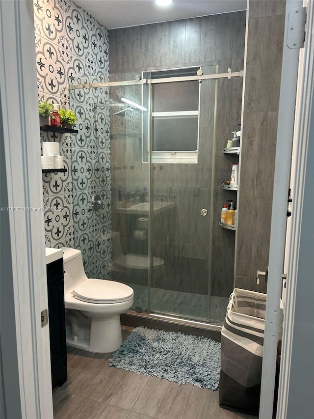 full bath with vanity, wood finished floors, toilet, and a shower stall