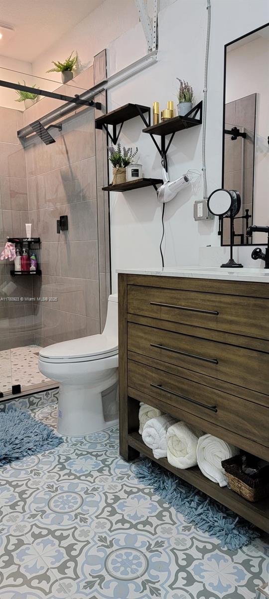 bathroom featuring vanity, toilet, and a shower stall