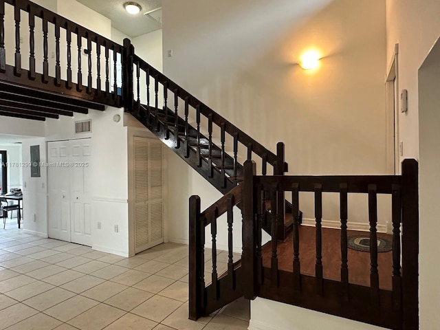11035 SW 132nd Ct Unit 13-3, Miami, FL 33186 - staircase with a towering ceiling, tile patterned flooring, and baseboards