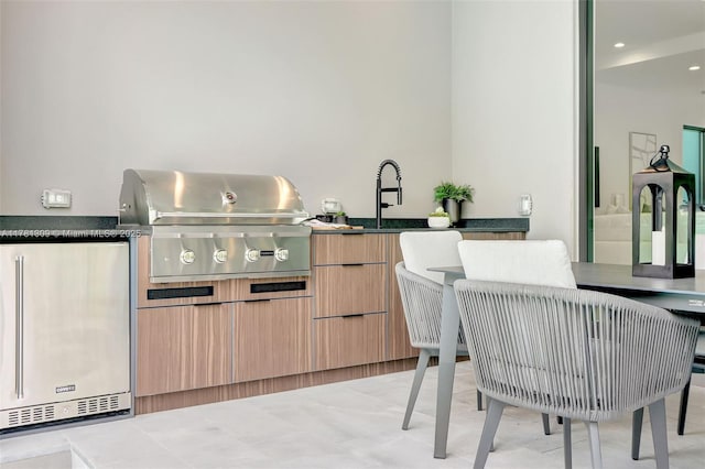 2851 W Trade Ave, Miami, FL 33133 - kitchen with light brown cabinets, modern cabinets, a sink, dark countertops, and refrigerator