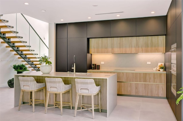 2851 W Trade Ave, Miami, FL 33133 - kitchen with a sink, light countertops, modern cabinets, and a breakfast bar