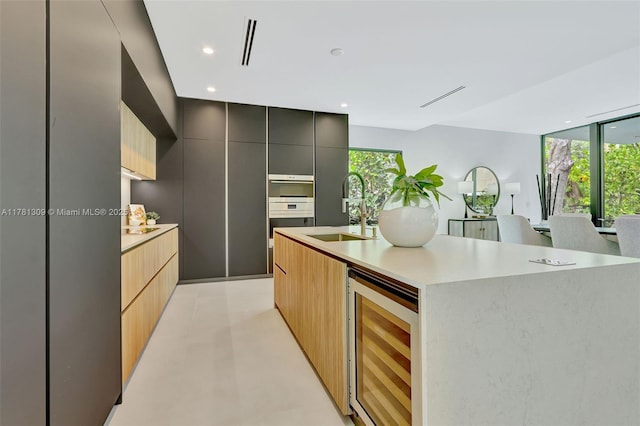 2851 W Trade Ave, Miami, FL 33133 - kitchen with a kitchen island with sink, modern cabinets, a sink, and wine cooler