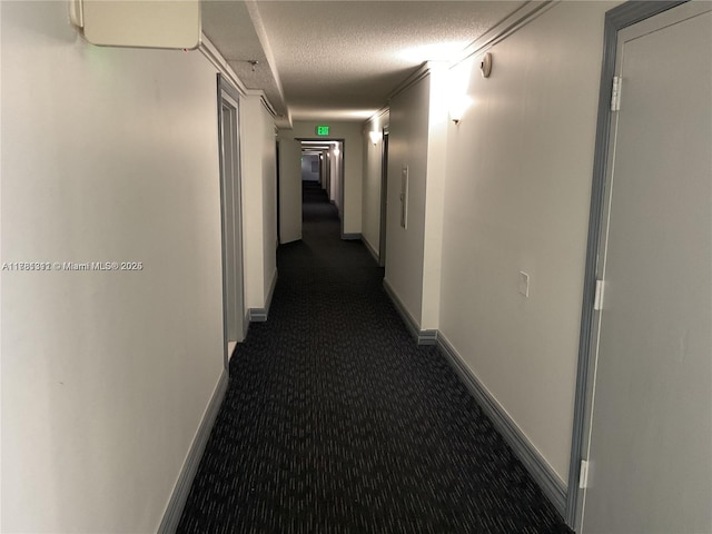 17011 N Bay Rd Unit 701, Sunny Isles Beach, FL 33160 - corridor featuring baseboards, a textured ceiling, and dark carpet