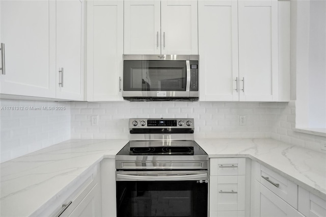 kitchen with decorative backsplash, appliances with stainless steel finishes, and white cabinetry