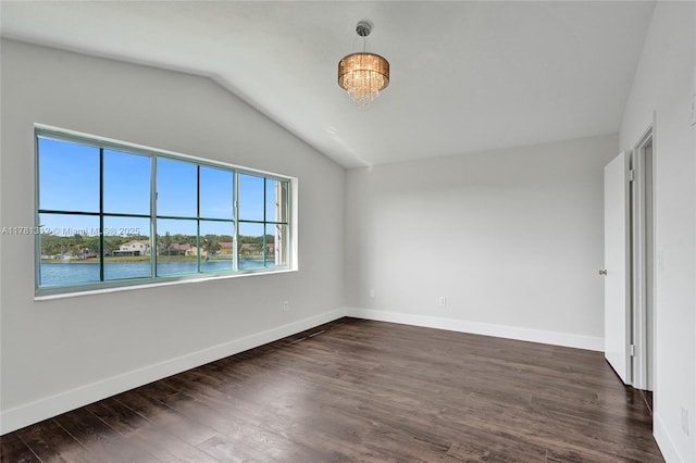unfurnished bedroom featuring dark wood finished floors, vaulted ceiling, and baseboards