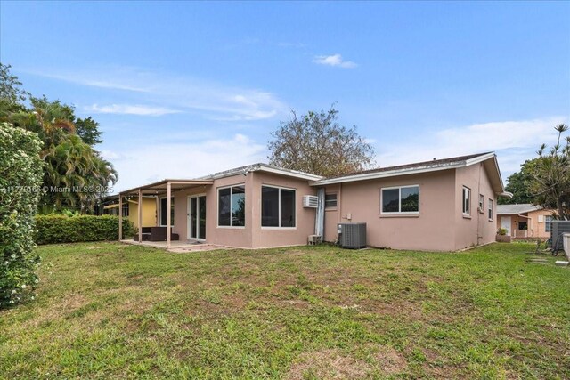 6001 NW 67th Ave, Tamarac, FL 33321 - back of property with a yard, cooling unit, a patio, and stucco siding