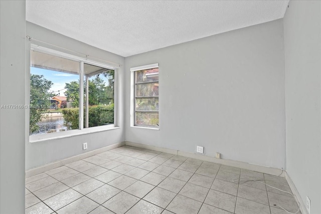6001 NW 67th Ave, Tamarac, FL 33321 - unfurnished room with a textured ceiling, light tile patterned flooring, and baseboards