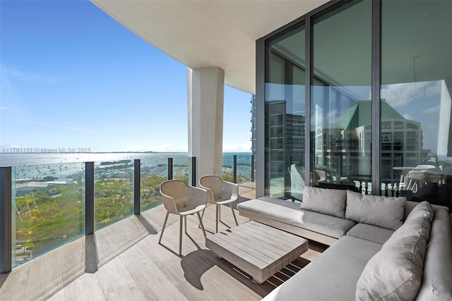 balcony with an outdoor hangout area and a water view