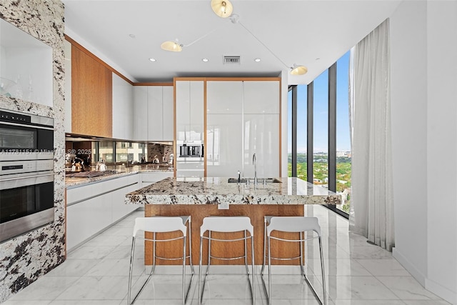 kitchen featuring a sink, visible vents, white cabinetry, marble finish floor, and appliances with stainless steel finishes