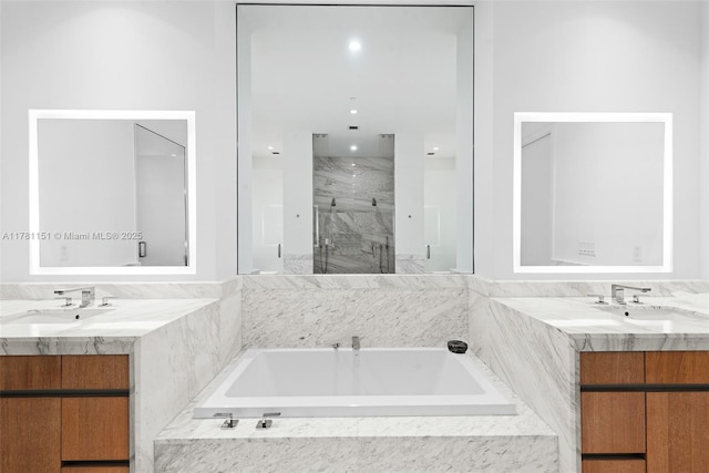 full bathroom featuring two vanities, a sink, and a marble finish shower