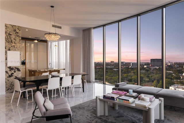 living room featuring expansive windows, an inviting chandelier, visible vents, and plenty of natural light