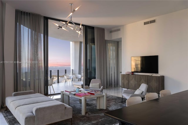 living area featuring expansive windows, visible vents, and a chandelier