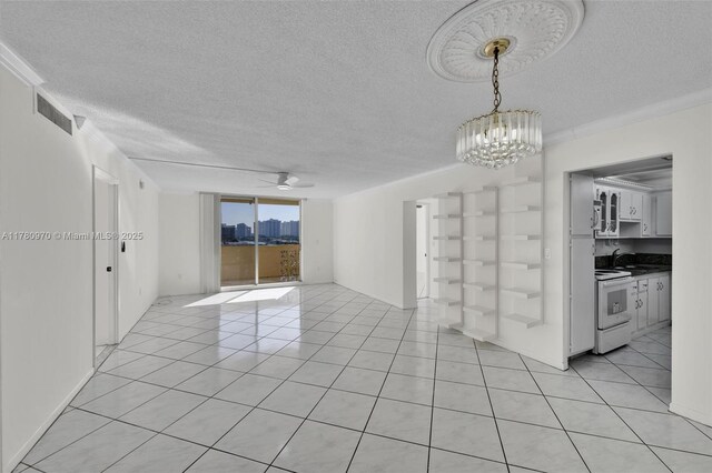 unfurnished room with light tile patterned floors, a sink, a textured ceiling, ceiling fan with notable chandelier, and a city view