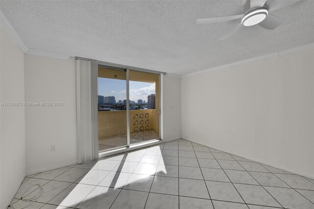 spare room with expansive windows, ornamental molding, a view of city, light tile patterned floors, and ceiling fan