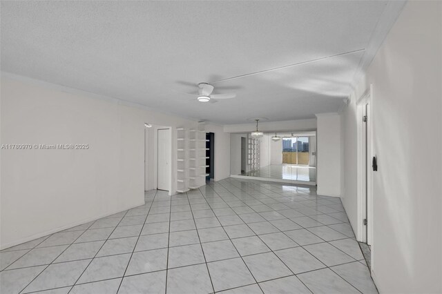 spare room featuring a textured ceiling, ceiling fan, and light tile patterned floors