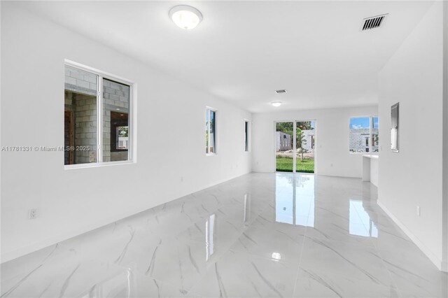 unfurnished room featuring visible vents, baseboards, and marble finish floor