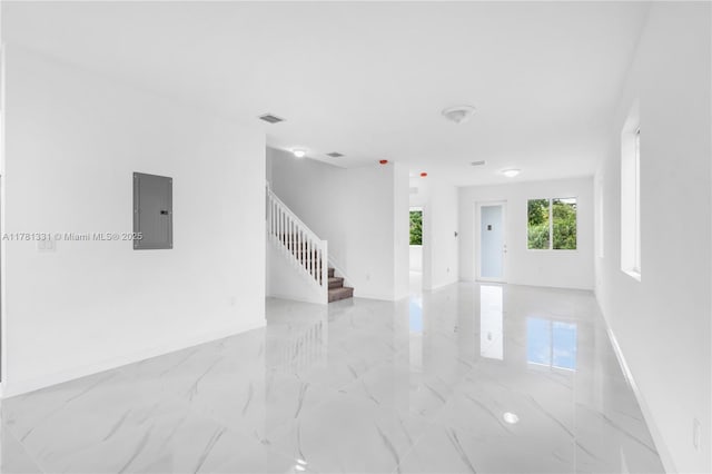 unfurnished room featuring visible vents, marble finish floor, electric panel, and stairway