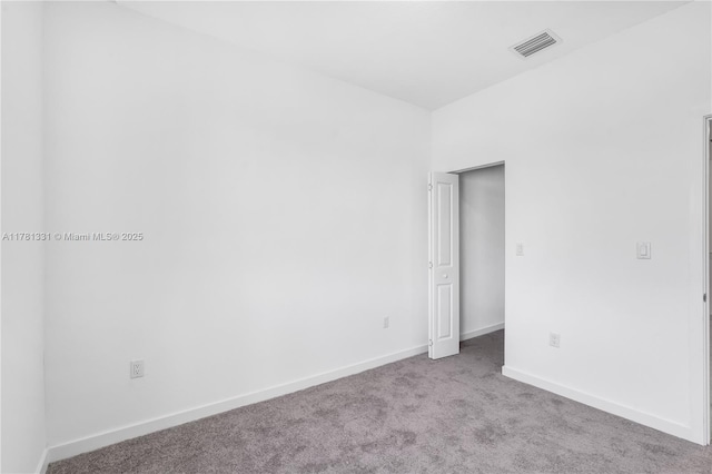 carpeted empty room featuring baseboards and visible vents