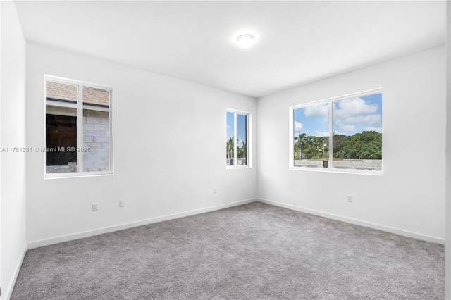 unfurnished room with carpet floors and baseboards