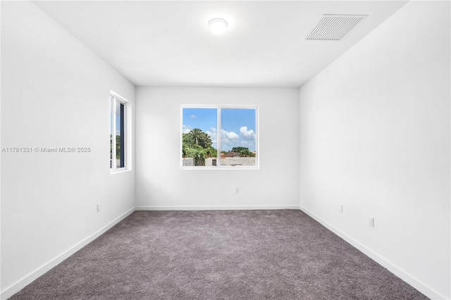 carpeted empty room featuring visible vents and baseboards