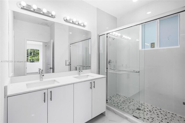 bathroom featuring double vanity, a sink, and a stall shower