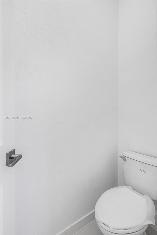 bathroom featuring toilet and baseboards