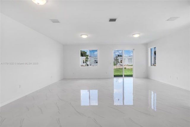 empty room featuring marble finish floor and visible vents