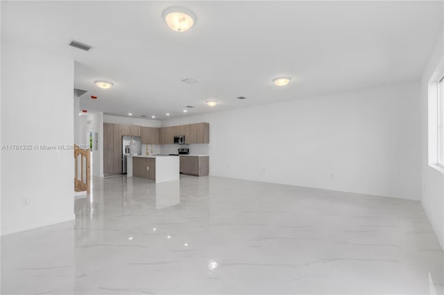 unfurnished living room with visible vents and marble finish floor