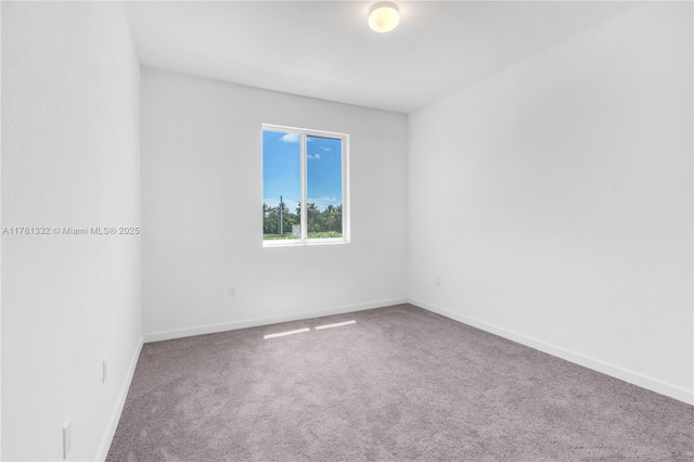 unfurnished room with carpet flooring and baseboards