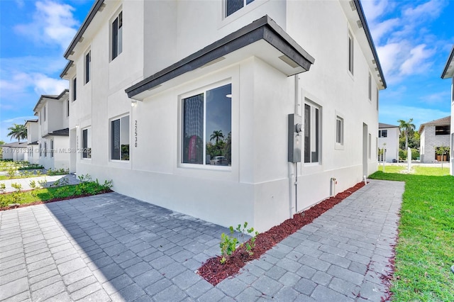 view of side of property with a patio and stucco siding
